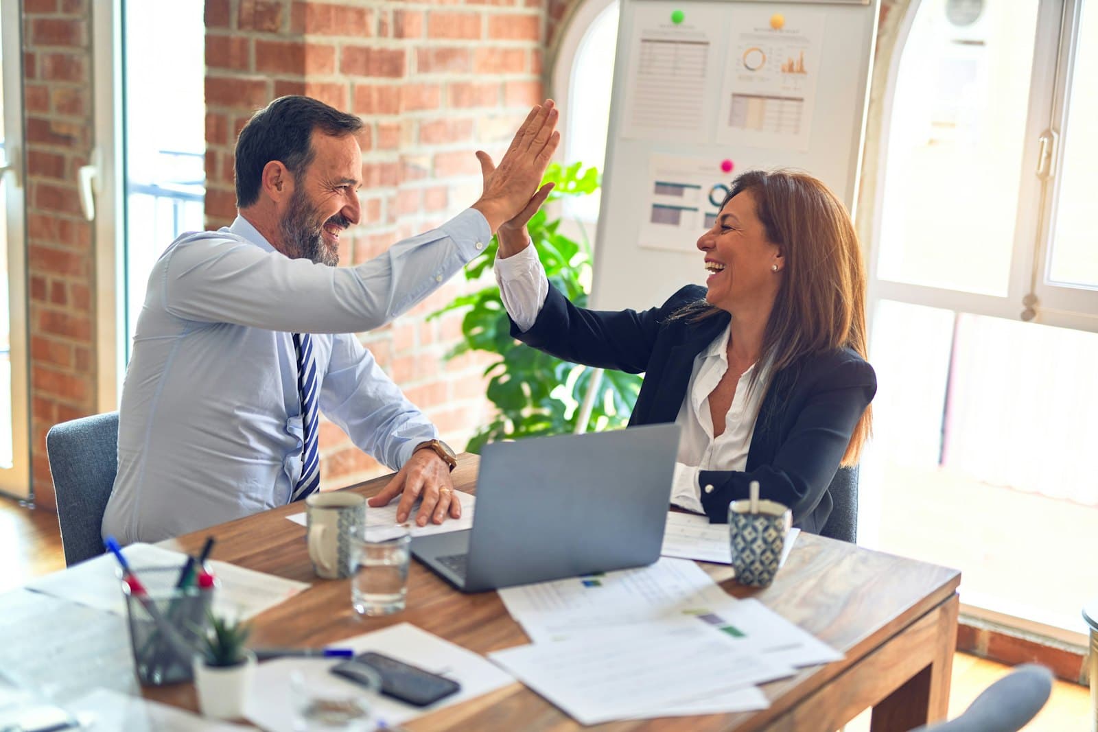 Two colleagues celebrating a working session in a bright office